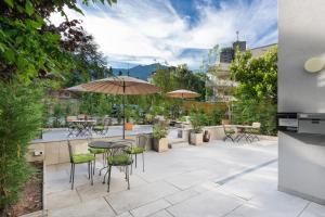 a patio with a table and chairs and umbrellas at BetweenLakes Apartment 1st floor in Interlaken +11 photos