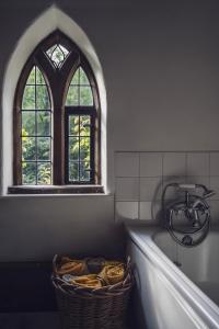 a bathroom with a bath tub and a window at Pictor Hall Lodge in Buxton