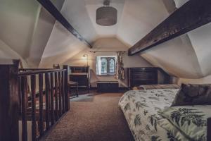 a attic room with a bed and a staircase at Pictor Hall Lodge in Buxton
