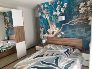 a bedroom with two beds and a painting on the wall at La brezza del mare ANTONIO COSTANTINI APPARTAMENTO in Cupra Marittima
