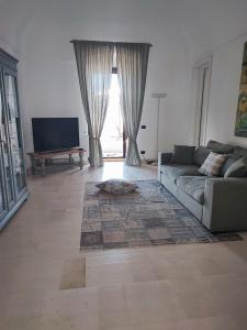 un soggiorno con un divano e una TV di Villa Castrignano a Monopoli