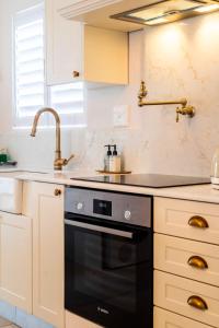 a kitchen with a sink and a black oven at Ukuthula - Tranquil home in Hout Bay, Cape Town in Hout Bay