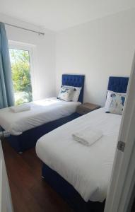 two beds in a room with a window at Seaside Escape Chalet in Sidmouth in Sidmouth