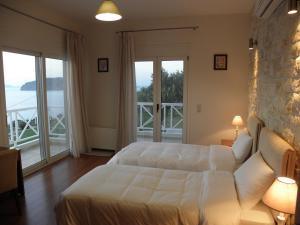 a bedroom with a bed and a couch and windows at Villa Tholos Crete in Kavoúsion