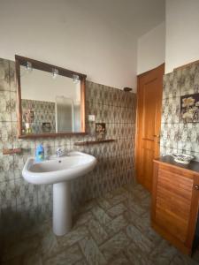 ein Badezimmer mit Waschbecken und Spiegel in der Unterkunft Anima Vintage in Carbonia
