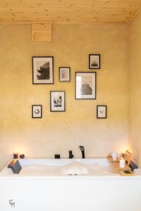 a bath tub in a room with pictures on the wall at Casa La Rueda - Alma del Cabriel in El Herrumblar