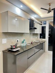 una cucina con mobili bianchi e un piano di lavoro di Skylar Home a Zirakpur