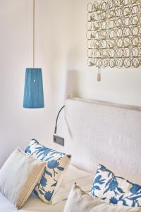 a bedroom with a bed with blue and white pillows at La Ferme D'Augustin in Saint-Tropez
