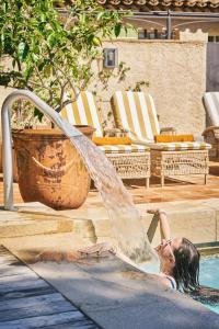 a young girl is playing in a fountain at La Ferme D'Augustin in Saint-Tropez