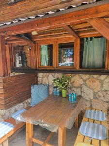 a wooden table and chairs in a stone wall at Snow Angel Jahorina in Jahorina