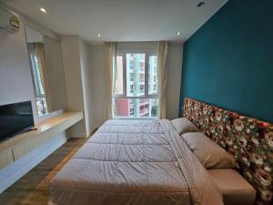 1 Schlafzimmer mit 2 Betten, einem TV und einem Sofa in der Unterkunft Stunning 1bdr in Fairytale Water park Condo Grande Caribbean in Pattaya South + 37 Fotos