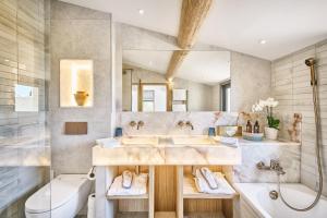 a bathroom with two sinks and a tub and a toilet at La Ferme D'Augustin in Saint-Tropez