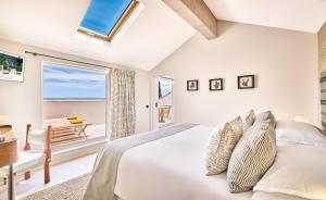 a bedroom with a bed with a view of the ocean at La Ferme D'Augustin in Saint-Tropez