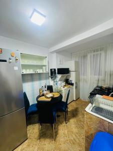 a kitchen with a table with chairs and a refrigerator at Apartament David in Neptun +16 photos