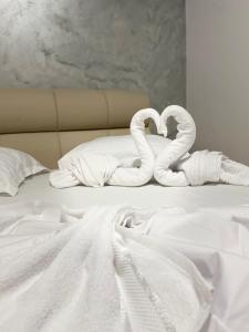 a bed with two towels in the shape of swans at Gut Aydin in Mamaia Nord