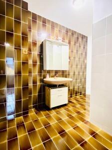 La salle de bains est pourvue d'un lavabo et d'un mur carrelé. dans l'établissement Cozy 4-Bedroom Apartment , Perfect for Groups, à Vienne