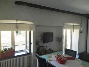 a dining room with a table and two windows at Monica & Rocco's House in Venaria Reale