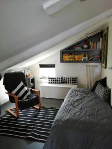 a bedroom with a bed and a chair next to a bed at Monica & Rocco's House in Venaria Reale