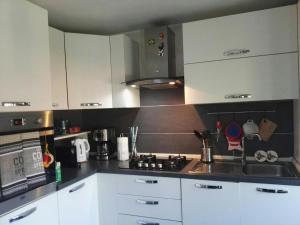 a kitchen with white cabinets and a stove top oven at Monica & Rocco's House in Venaria Reale +16 photos