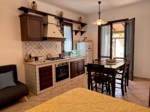 a kitchen and dining room with a table and a stove at Monolocale da Mariolina in Macari +28 photos