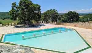a large swimming pool in a yard with trees at Trulli Panoramici in Alberobello