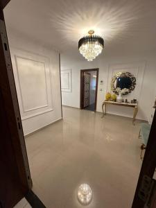 a large white room with a chandelier and a floor at ORAN MOBILART 4 PIECES MODERN apartement in Oran