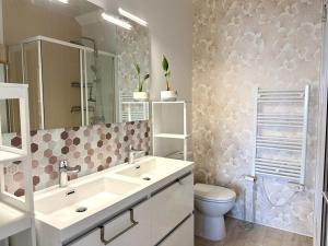 a bathroom with a sink and a toilet at Les Lutins Villa Le Pouliguen in Le Pouliguen +29 photos