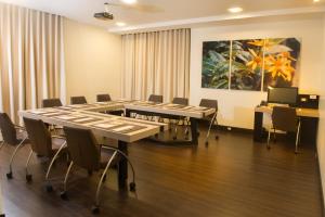 una sala de conferencias con mesas, sillas y una pintura en Oro Verde Loja, en Loja