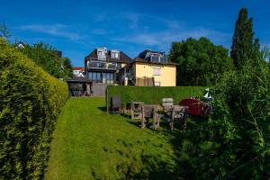 a yard with a table and chairs in front of a house at Ferienwohnung Haus am Seeufer Steuerbord in Waren