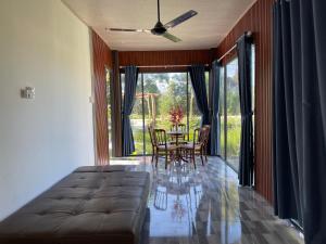 Una sala de estar con un sofá y una mesa con sillas. en TUTA House, en Cam Lâm