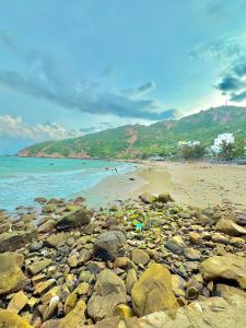 einen Strand mit Felsen und Menschen auf dem Wasser in der Unterkunft Đảo Bình Ba, Khách sạn view biển, tầng cao, không nhận khách quốc tế, phòng giường đôi, nhận cọc mới giữ phòng in Ấp Binh Ba