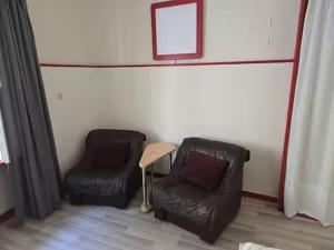 two leather chairs and a table in a room at Alte Post - Mond in Gurk