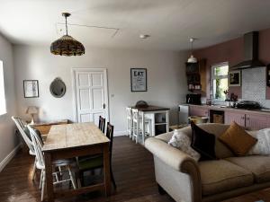 戈尔韦Rose Cottage的客厅里有一张沙发和一张桌子。