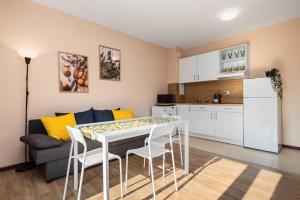 a kitchen and a living room with a table and chairs at Nest Green Apartment Varna in Varna City