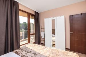 a bedroom with a bed and a large window at Nest Green Apartment Varna in Varna City