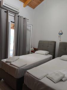 two beds sitting in a room with a window at Paleros vacation in Paleros