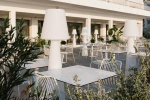 un patio al aire libre con mesas y sillas con plantas en AluaSoul Ibiza - Adults only, en Es Canar