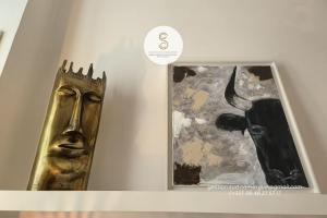 a gold mask on a shelf next to a painting at La Pitchoune Arles Centre in Arles