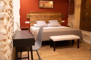 a bedroom with a bed with a desk and a chair at Arena Centro Rooms&Suites in Seville