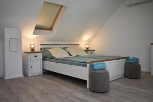 a bedroom with a bed with two night stands and two lamps at Gőzhajó Loft - Családi ház terasszal, 2 fürdőszobával, kerékpárral in Szentendre