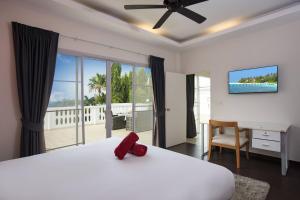 Un dormitorio con una cama y un escritorio y una ventana. en Grand 5BR Pool Villa Sea la Vie, en Rawai Beach 45 fotos más