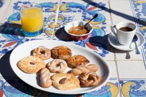 a plate of doughnuts on a table with a glass of orange juice at Hotel Girasole in Panarea