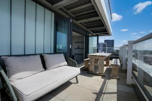 a couch on the balcony of a building at Athera - Walthamstow Central Sub-Penthouse 2 bedroom, 2 bathroom Incredible views! in London