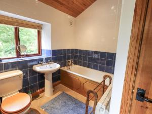 a bathroom with a tub and a sink and a toilet at Chapel Cottage in Cleator +44 photos