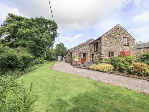 an exterior view of a stone house with a yard at Chapel Cottage in Cleator