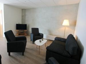 uma sala de estar com duas cadeiras e um sofá e uma televisão em Hotel West em Patreksfjörður