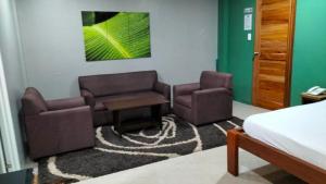 a hotel room with two chairs and a bed at Hope Pension House - Danao in Danao City