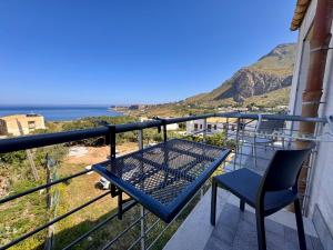 balkon ze stołem i krzesłem oraz oceanem w obiekcie Bed and Breakfast Stella del Sud Makari w mieście Macari