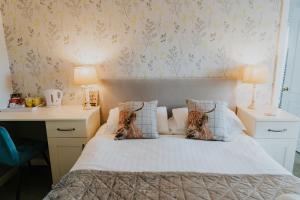 a bedroom with a bed and a desk with two lamps at Crossroads House in Carlisle