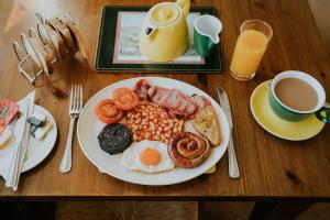 a plate of breakfast food on a wooden table at Crossroads House in Carlisle